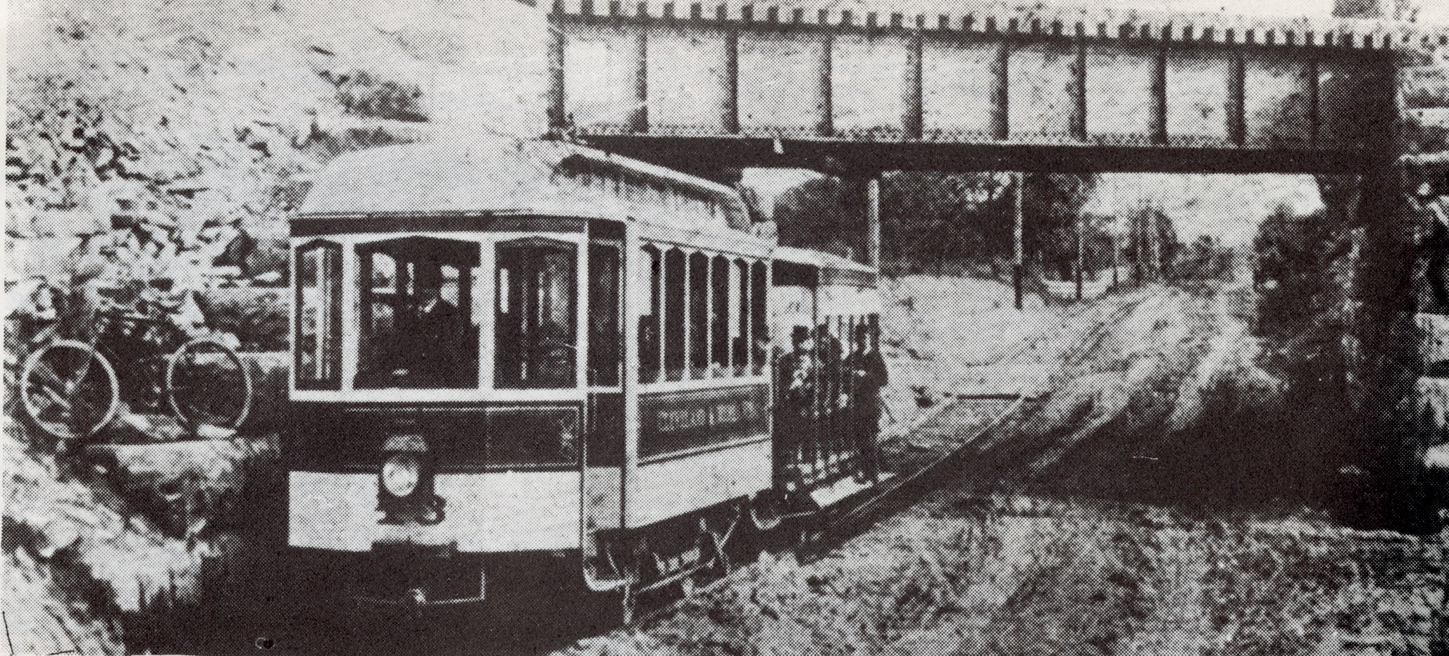 A Cleveland and Berea Street Railway Car towing a horsecar, both passing under a steam railroad bridge, circa 1890s. Text: Cleveland and Berea Railway