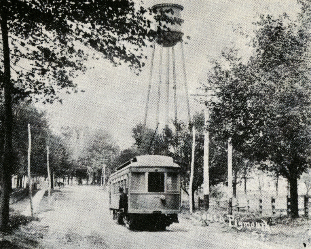 An early streetcar, number 2, stoppped on South Plymouth street with trees and a water tower in the background. Text: "South Plymouth St."