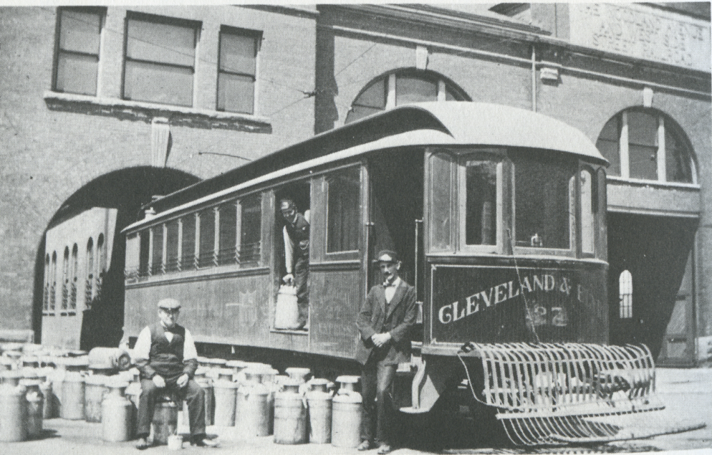 A crew of a milk streetcar pose in 1898 while unloading milk jugs